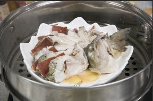 將鱸魚成花狀擺好，將火腿切片放入各縫隙中，放入鍋中隔水蒸12分鐘拿出，撒上蔥花即可。