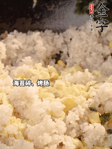 剩米飯下鍋炒散，依次下玉米粒、雞蛋、烤腸、海苔碎翻炒均勻。