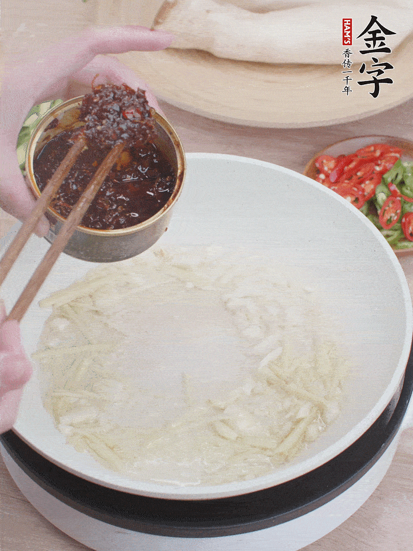 起鍋熱油，姜蒜、金字火腿干貝醬煸香。
