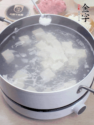 豆腐切成大小均勻正方體，鍋內(nèi)放水，加一點鹽焯水10秒。