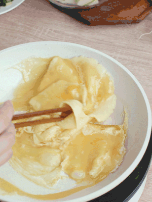 油6成熱時，下雞蛋液，邊緣凝固時翻拌成塊狀。