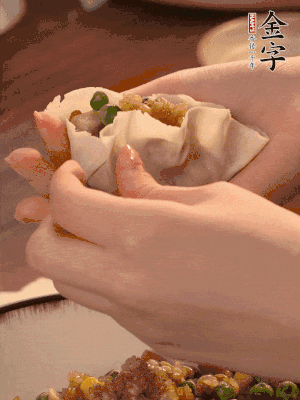 取一大勺餡料放進餃子皮里，用大拇指按住頂部餡料，再用虎口掐出形狀。