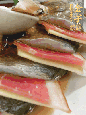 魚肚中塞蔥結(jié)、火腿片，魚身上碼放姜片、火腿片，倒入混合的料汁。